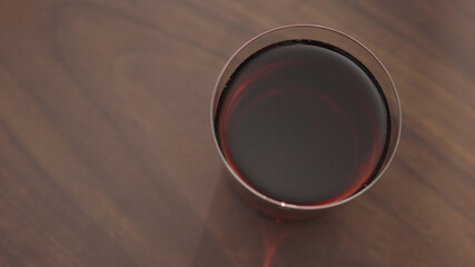 red drink in tumbler glass on walnut table with copy space
