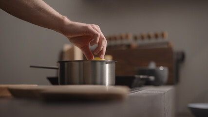 Fototapeta na wymiar man hand put fettuccine into boiling water in saucepan