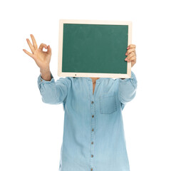 casual woman hiding behind a green board