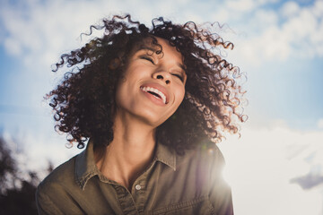 Photo of charming cheerful wavy hairdo dark skin person toothy smile closed eyes have good mood...