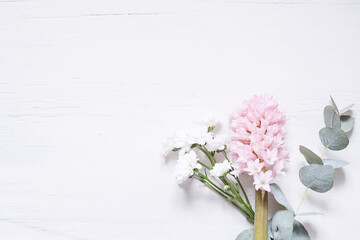 Delicate flowers on a white wooden background. Spring template.