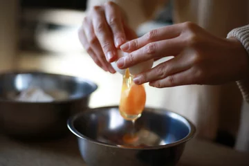 Fotobehang 卵を割る女性の手元 © yamasan
