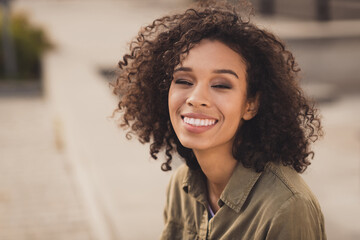 Portrait of peaceful cute curly hairstyle dark skin lady beaming smile enjoying travel excursion good mood sightseeing outdoors