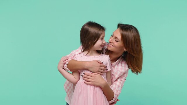 Happy woman in pink clothes have fun cute child baby girl 5-6 years old. Mommy little kid daughter stand behind hug embrace isolated on pastel blue background studio Mother's Day love family concept