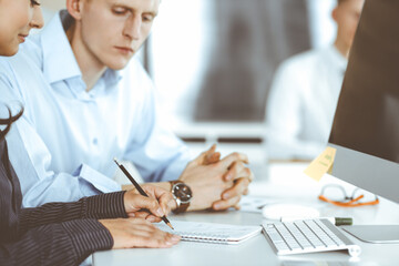 Obraz premium Business woman and man are discussing questions while using computer and blocknote in modern office, close-up. Teamwork in business