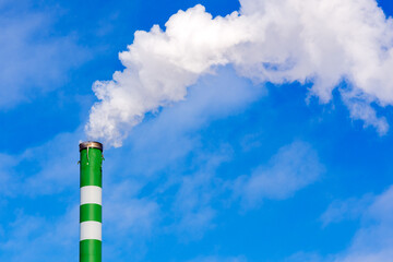 One Industrial smoke pipe from chimney on blue cloudy sky.