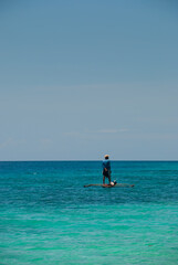 Fisherman standing on his small boat in a calm sea