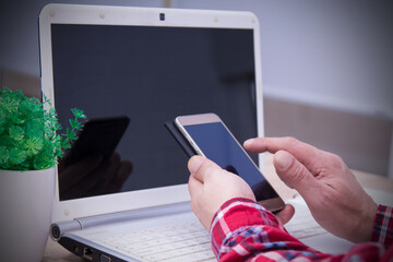 man with laptop and using mobile phone