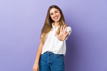 Fototapeta na wymiar Young woman over isolated purple background counting five with fingers