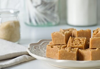 Homemade fudge cut into cubes on plate on white kitchen counter
