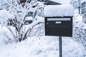 A letterbox with snow on top of it. 