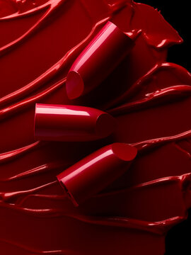 Broken red lipsticks over smudged lipstick background