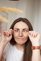 Funny millennial woman with glasses in eco style kitchen. Trendy colors. Natural light