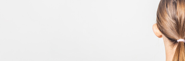 Fototapeta premium Lop-eared female ear, rear view on a light background. Auricle defect. Banner.