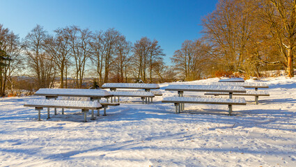 Snow-capped picknick area along a hiking trail in winter