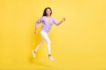 Fototapeta na wymiar Full length body size view of lovely cheerful slender girl jumping running distance isolated over bright yellow color background