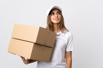 Young delivery woman over isolated white background and looking up