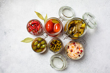Homemade pickled and fermented vegetables in glass jars, top view. Home preservation concept.