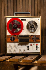 vintage reel-to-reel tape recorder on wooden background