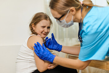Fototapeta premium Positive pediatrician doctor vaccinating or inoculating preschool child