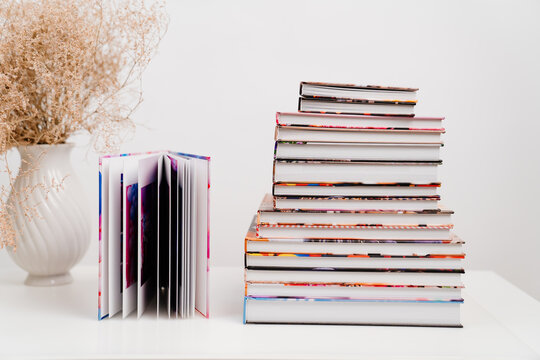 a stack of photobooks and an open photo album. the printed products.