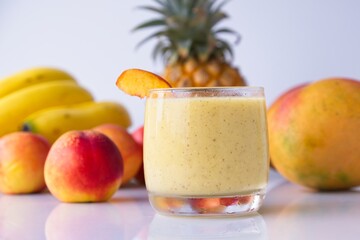Healthy fruit smoothie in glass in front of fresh fruit