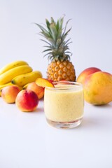 Healthy fruit smoothie in glass in front of fresh fruit