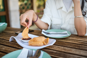 Woman having thai shrimp flavored appetizer before meal