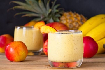 Healthy fruit smoothie in glass in front of fresh fruit