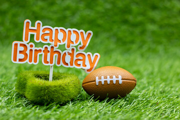 American Football with sign Happy Birthday is on green grass