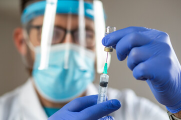 male doctor preparing to give coronavirus vaccine