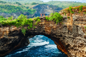 Family walk by natural bridge, look at natural sea pool Broken Bay. Popular Bali travel...