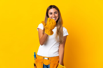 Young hispanic electrician woman over isolated yellow wall inviting to come with hand. Happy that you came