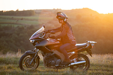 Fototapeta premium Man on his motorbike riding into sunset