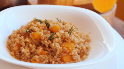 Pumpkin risotto, recipe with rice and pumpkin on rustic table with ingredients. Autumn and Halloween recipe.