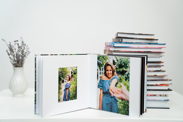stack of books. open photobook from photo shoots of a beautiful happy woman
