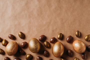 Easter concept card with golden eggs and candy sweet frame falt lay on brown background