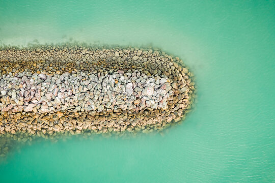 Aerial view of breakwater structure along Cannonvale harbour and city port, Queensland, Australia.