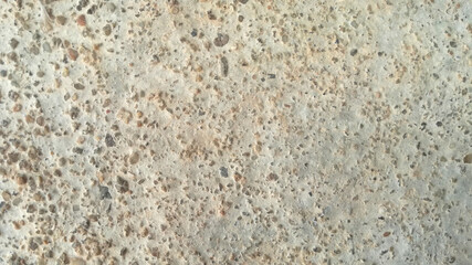 Perforated and rough concrete wall for background.