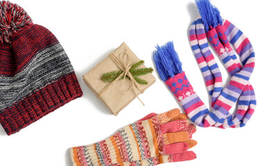 winter hat, gift box and multicolored knitted scarf on a white background