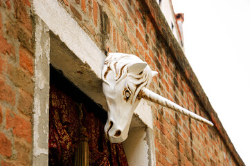 Unicorn head on building in Venice, Italy. Architectural detail. 