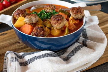 Vegetable soup with meat served in a bowl with spoon