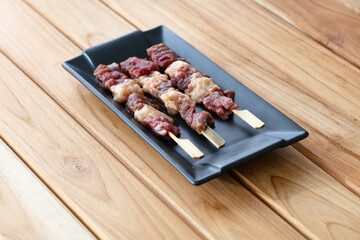 fresh raw meat pork beef sliced on square plate isolated on wooden background, shabu, hot pot ingredients