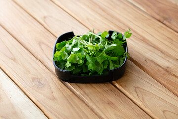 fresh raw celery sliced on square plate isolated on wooden background, shabu, hot pot ingredients