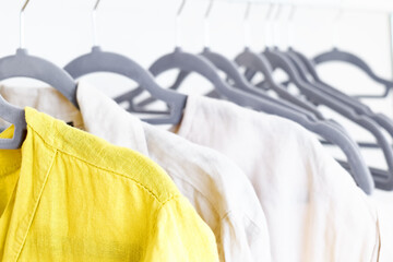 Linen clothes on gray hangers on the clothes rack. Slow Fashion. Conscious consumption. Crisis in the fashion industry, retail. Eco-friendly, Sustainable seasonal Sale concept. Zero waste.