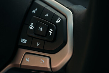 Obraz premium Multi-functions control buttons on modern steering wheel in new car, close up.