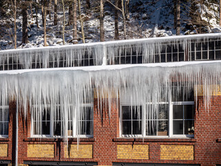Eiszapfen hängen an einer Dachrinne im Winter