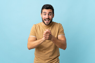 Young handsome man with beard over isolated background laughing