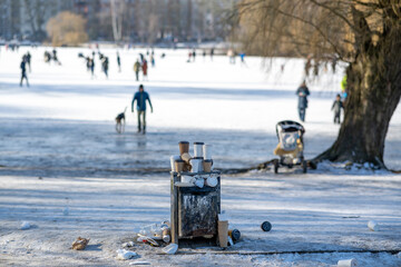 Winterliche Parklandschaft mit Mülleimer der überquillt von Coffee to go bechern