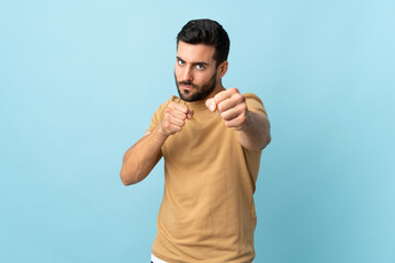 Naklejka premium Young handsome man with beard over isolated background with fighting gesture